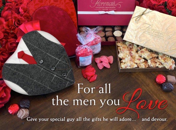 A Valentine's Day-themed display featuring Florence's Exquisite Chocolates in Rexburg, Idaho. The setup includes a variety of beautifully packaged chocolates and confections, such as a heart-shaped box designed to look like a suit with a red tie, a gold box filled with nut brittle, and an assortment of truffles and candies. The display is adorned with red roses and heart-shaped decorations, creating a romantic and inviting atmosphere. The text on the image reads, "For all the men you love. Give your special guy all the gifts he will adore... and devour.