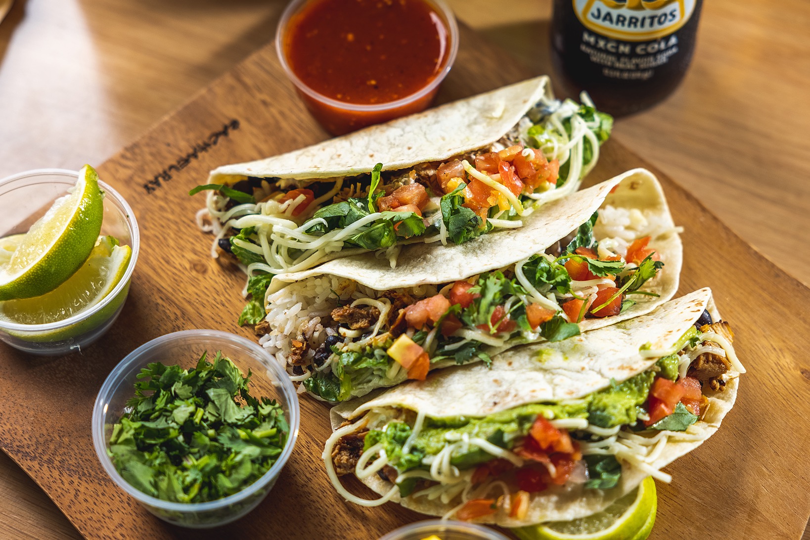 3 soft tacos with chicken and fresh toppings and red salsa and mexican soda