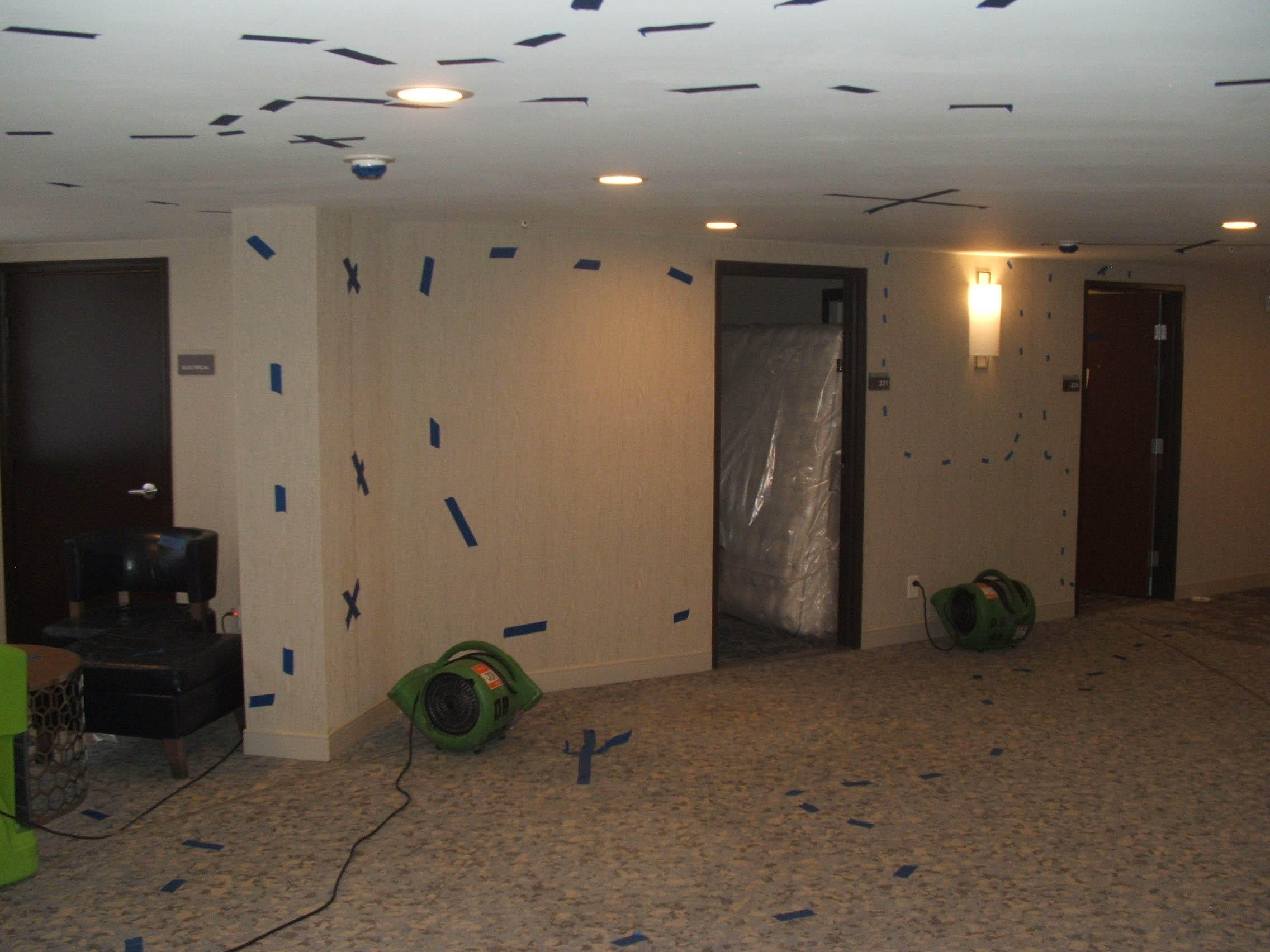 A commercial space during restoration with containment put up and equipment being utilized.