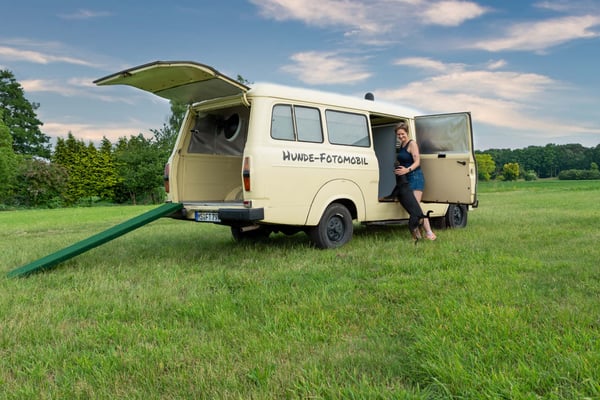 Fotogebell Hundefotografie - Carsten Pöhler Frau steht mit Hund vor mobilem Studio, Outdoor Hundefotografie Münster mit natürlichem Licht und authentischer Interaktion.