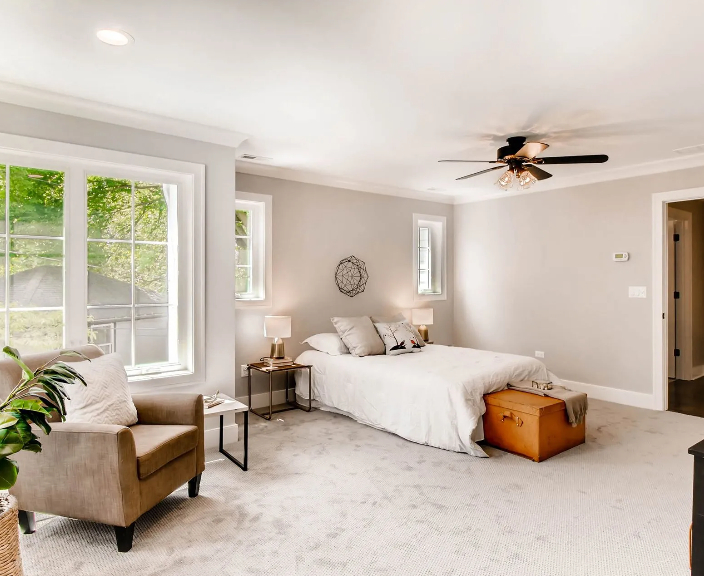 Spaciously designed master bedroom addition with plush beige carpet, recessed ceiling lighting, a tr 