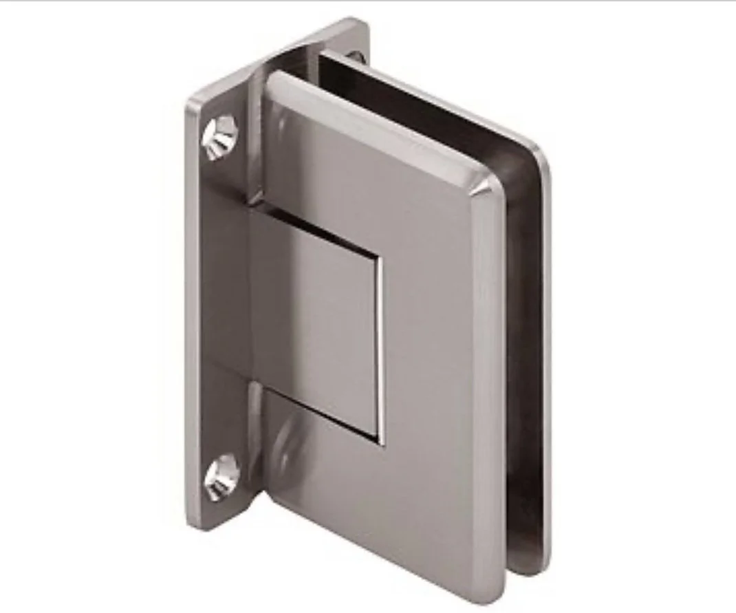 A beveled wall mount hinge, made of brushed metal, is shown against a white background. The hinge is designed to attach to a wall and support a door or panel, likely made of glass, with its unique mounting plate and pivoting mechanism.