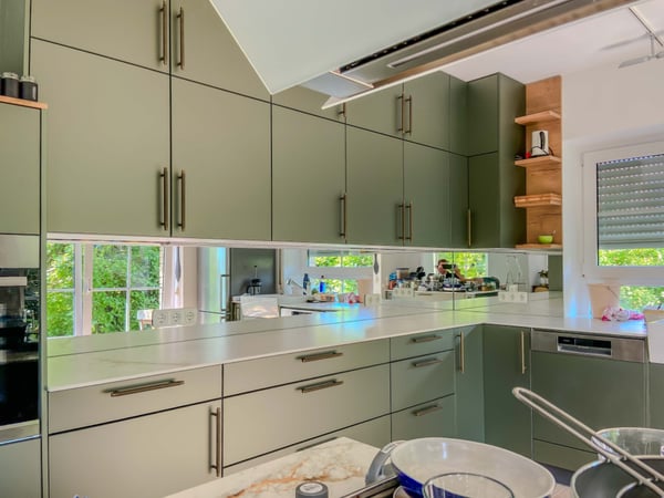Küchenrückwand aus Spiegelglas als pflegeleichter und lichtreflektierender Spritzschutz.