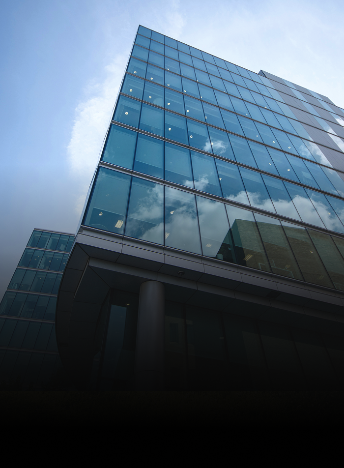 A bottom-up view of a glass skyscraper.