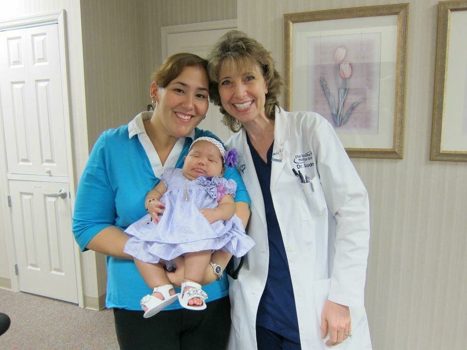 Dr. Sandy Goodman and her fertility patient holding a baby.