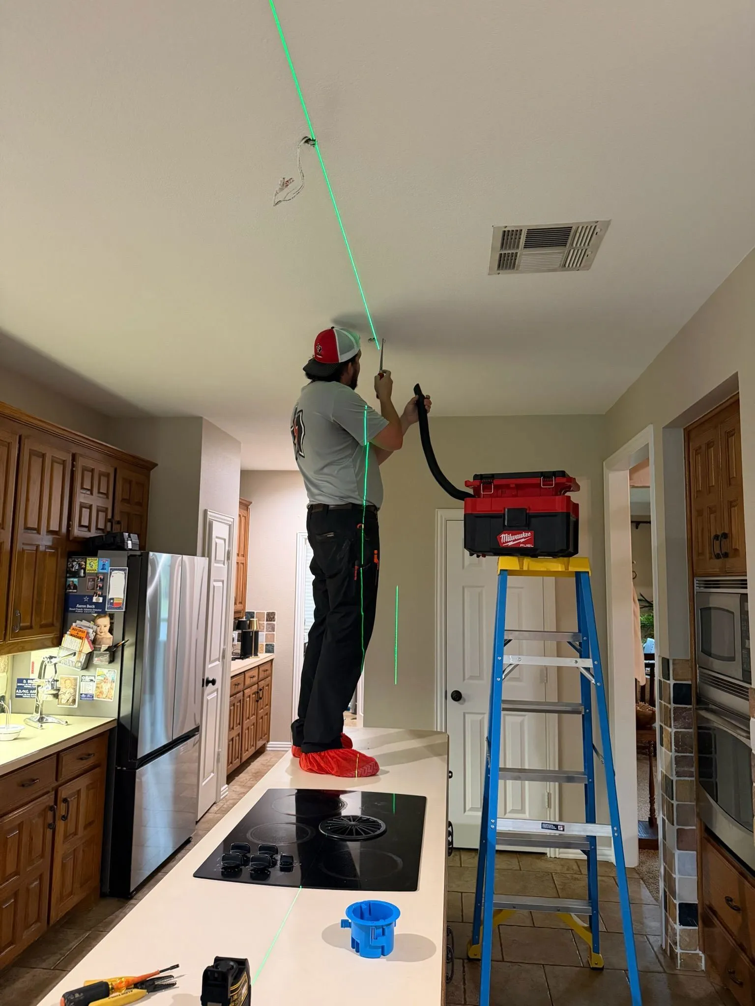Tier One Electric technician performing ceiling electrical work inside a home during a professional service visit.