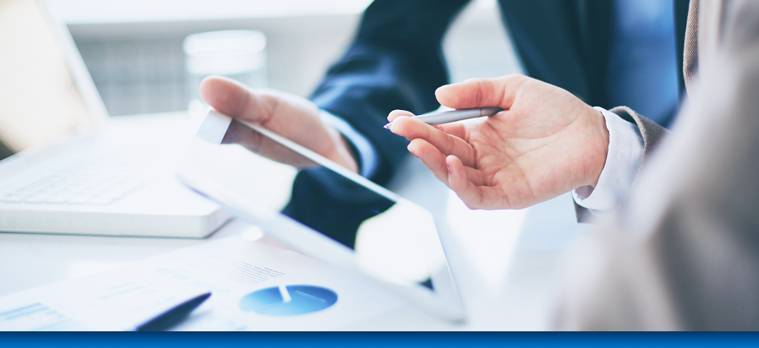 Close-up of two professionals looking at a tablet.