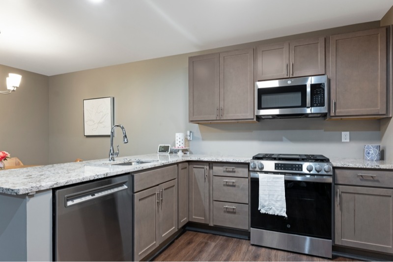 Modern kitchen with high-end appliances in a Brookwood Estates of Taylor residence. Each 1,100 square foot two-bedroom condominium features quality finishes for carefree senior living.