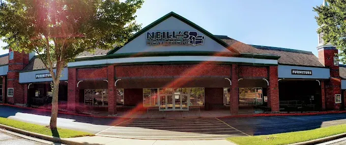 Exterior view of Neill&rsquo;s Homestore storefront with the business sign above the main entrance and furniture signage visible on the building.
