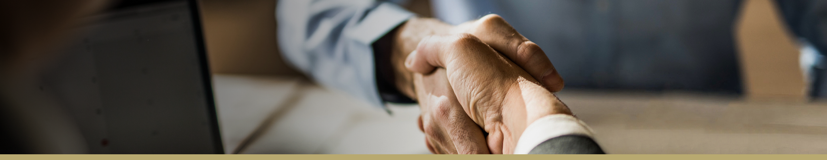 Close-up image of an advisor and client shaking hands.