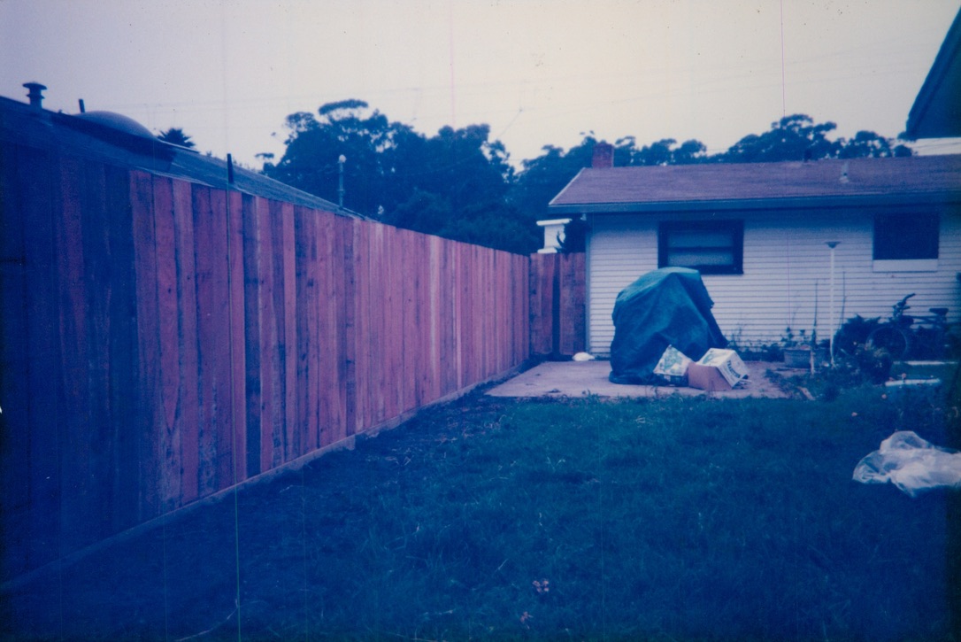 Long wood privacy fence installation along a residential property line for enhanced backyard security and privacy.