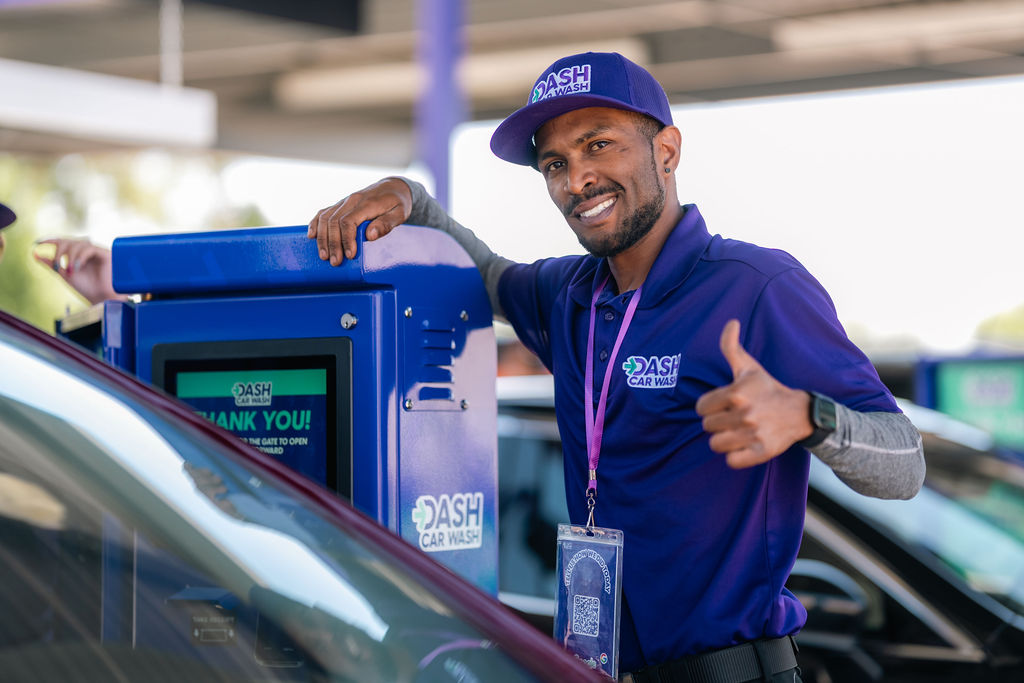 Friendly DASH Car Wash team member welcoming customers to the Olive Ave location. 