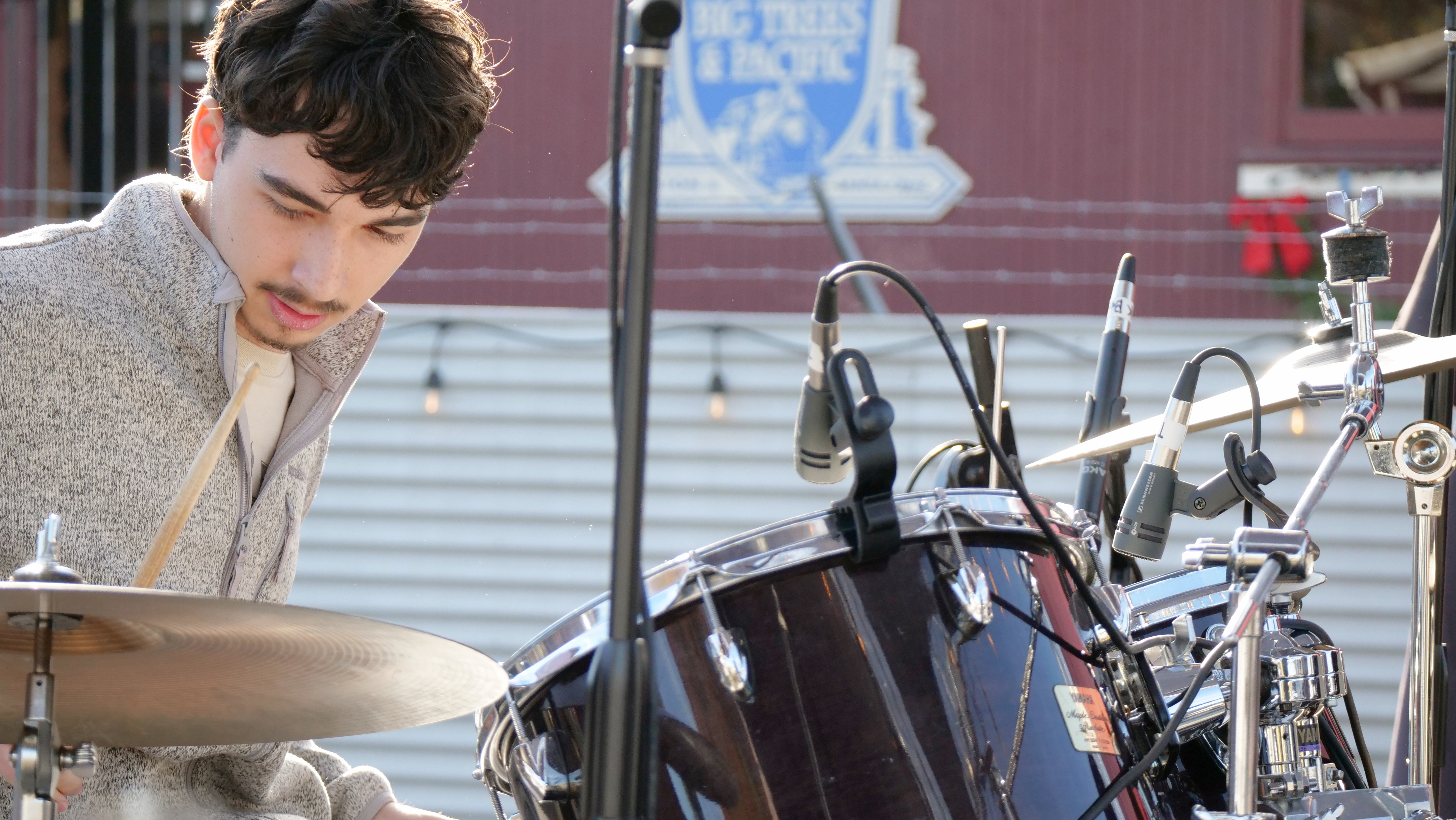 Student drummer performing live, showcasing rhythm training and stage performance experience.