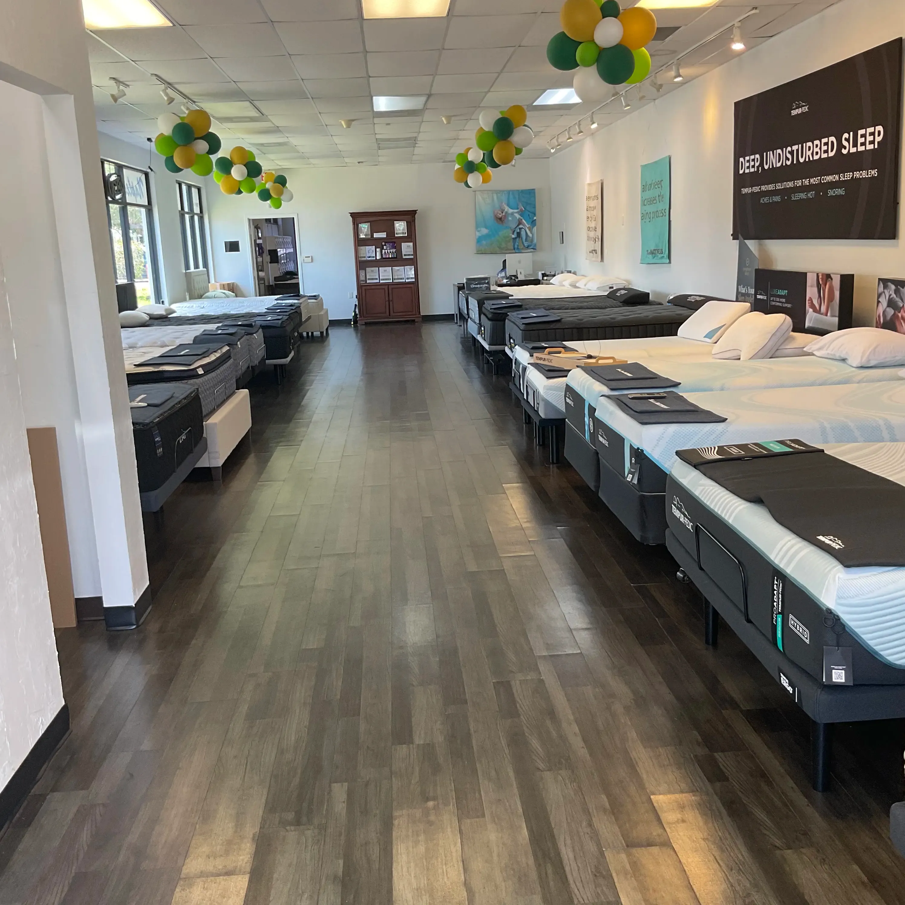 Inside Naples Mattress North, showing rows of mattress displays in a clean, spacious showroom.