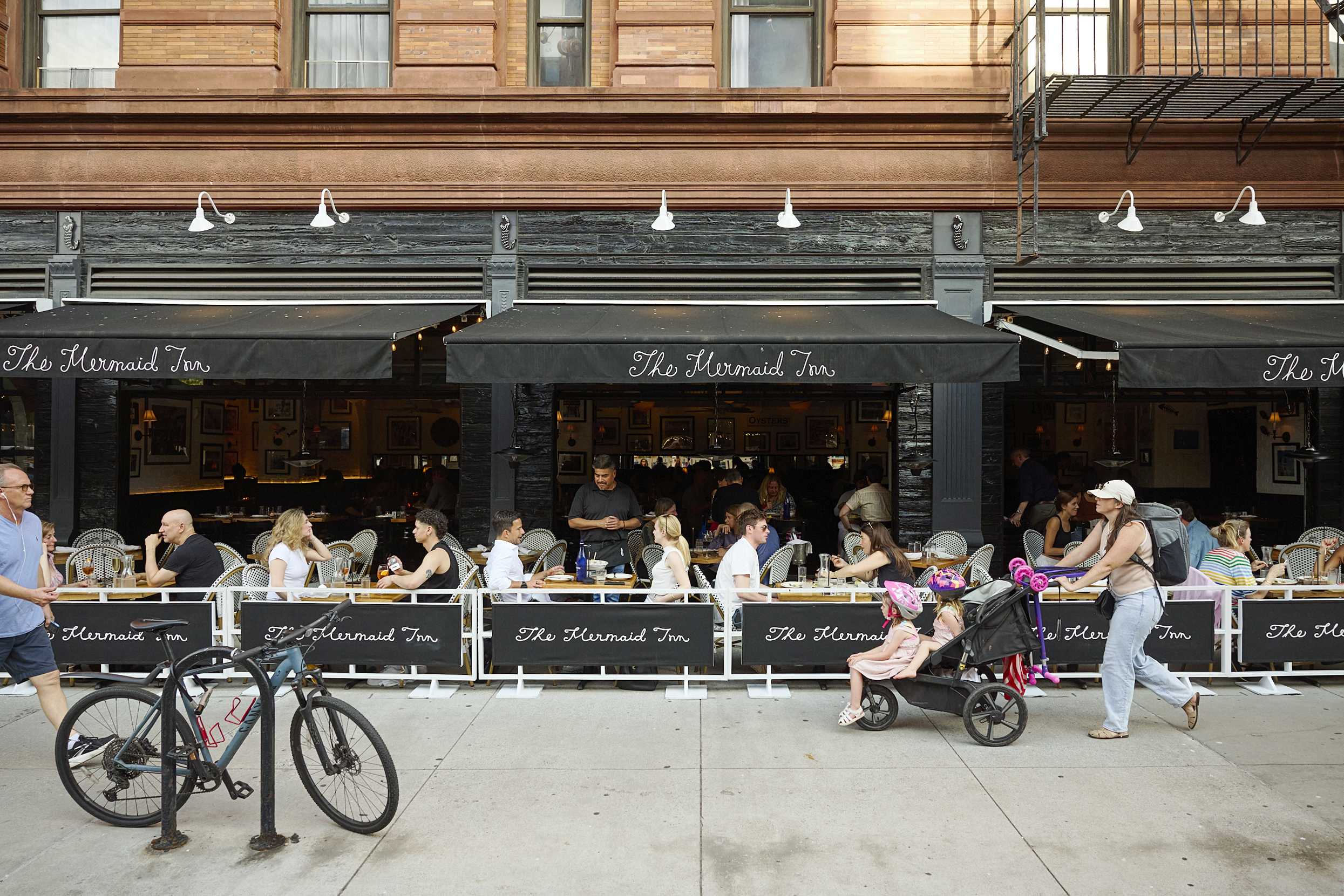 Guests enjoy outdoor dining at The Mermaid Inn, a beloved seafood restaurant in New York City known for fresh oysters, lobster rolls, seasonal seafood dishes, and exceptional hospitality.