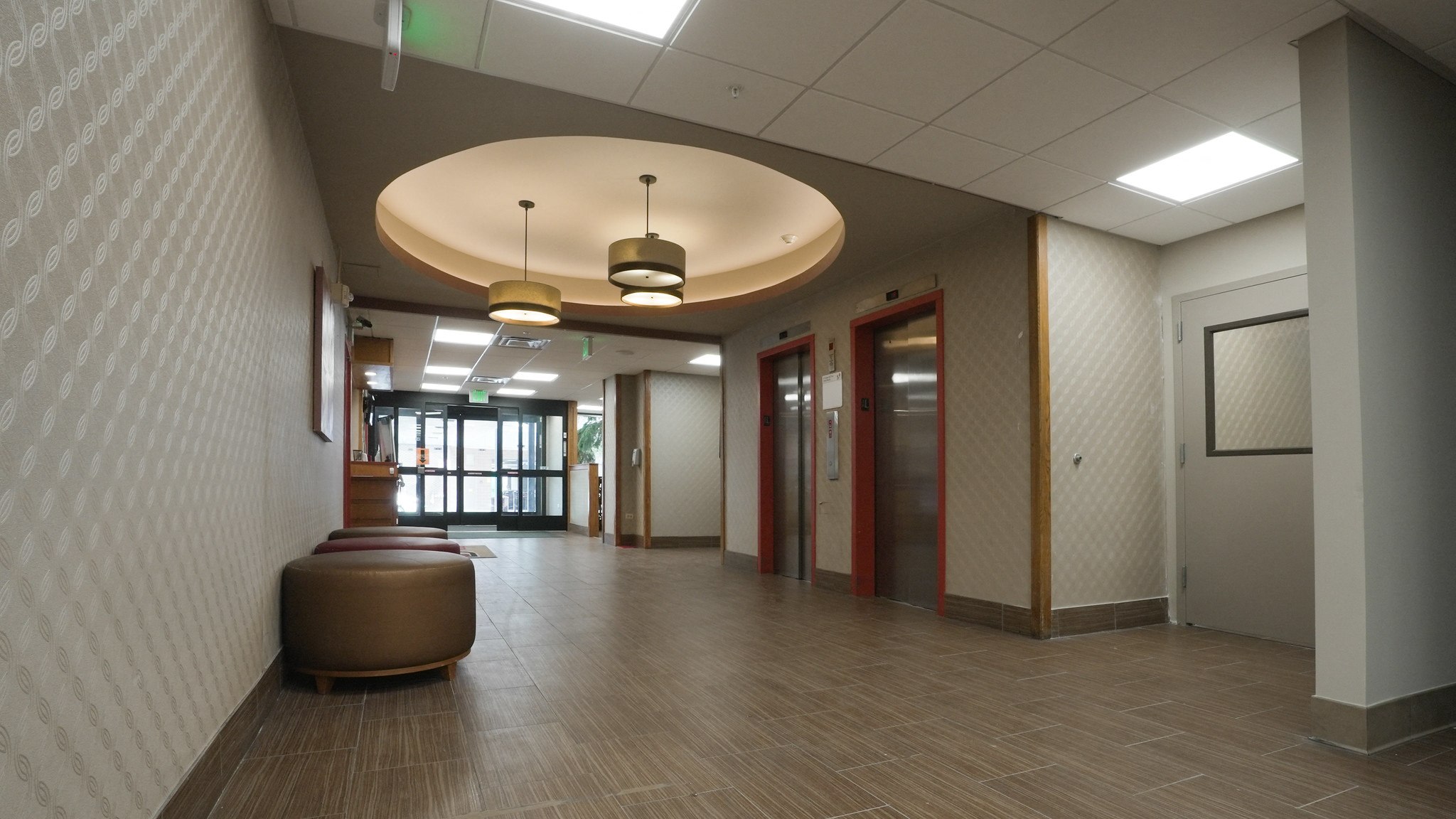 A hallway with a round light fixture and a bench.