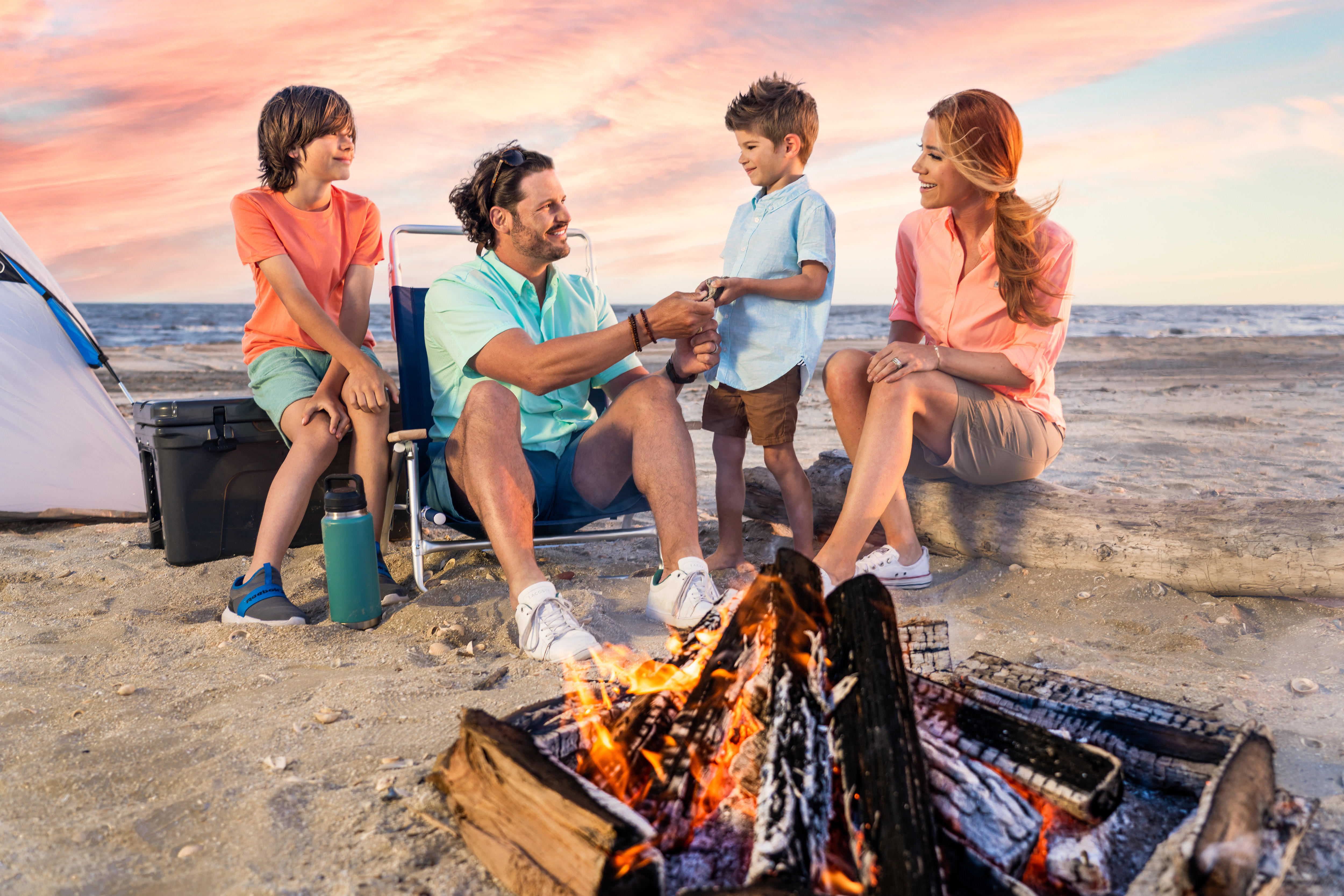 Family camping beachside around a fire at Sea Rim State Park in Port Arthur, Texas