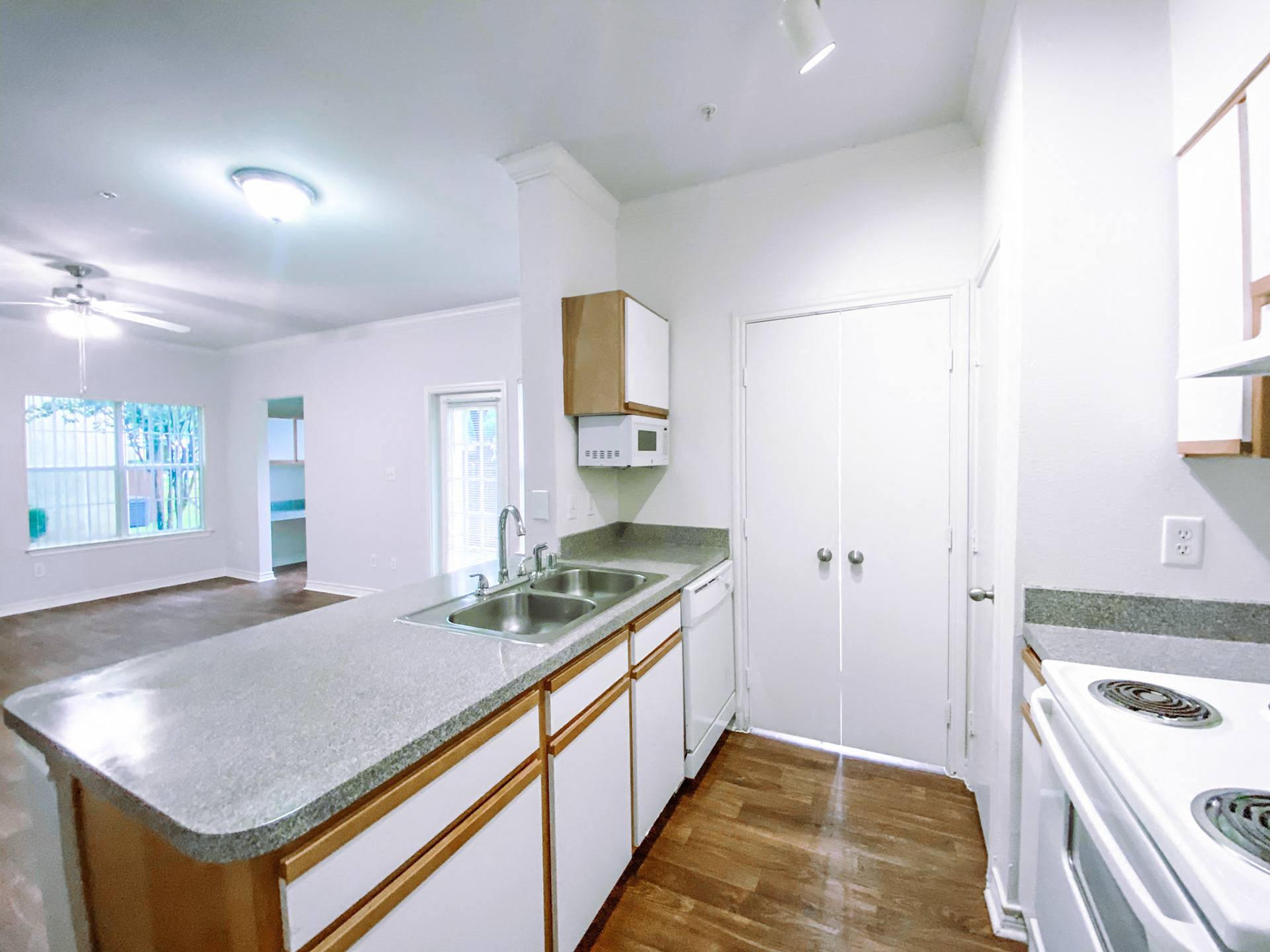 White kitchen appliances with hardwood flooring