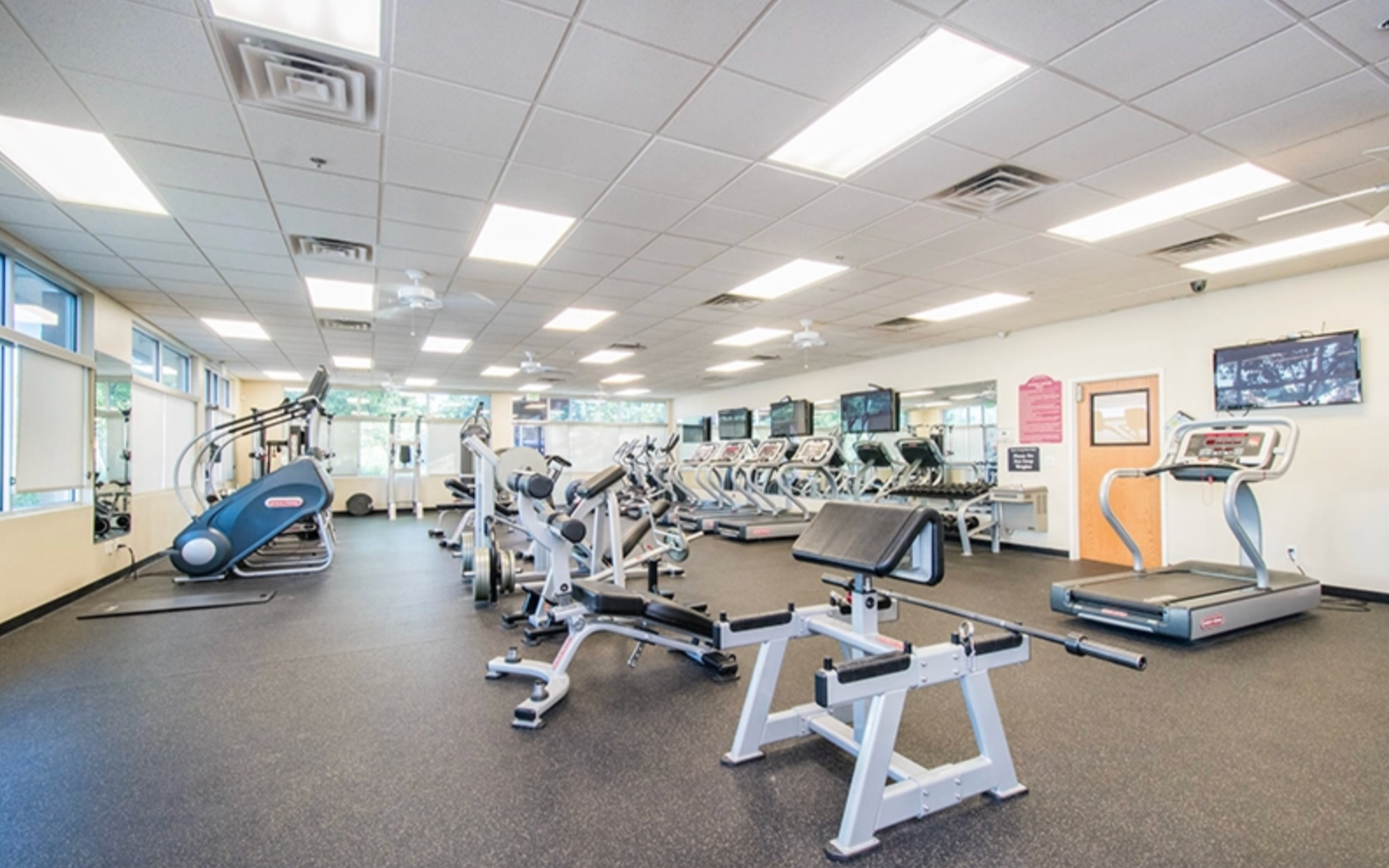 Fitness center with cardio machines and free weights.
