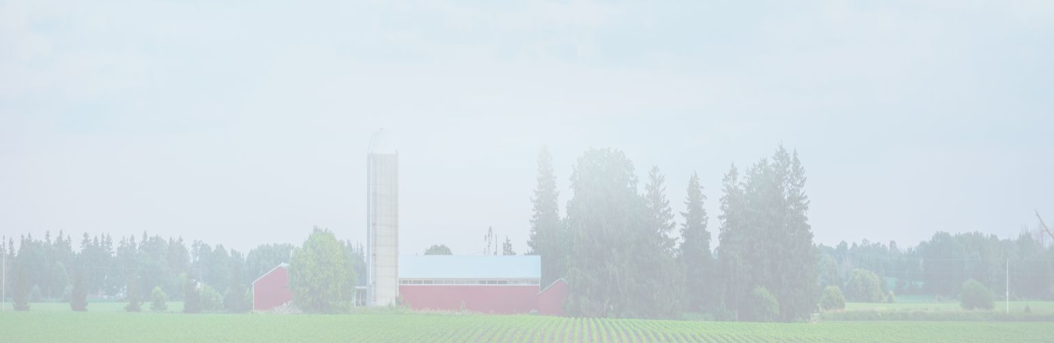 A farm with a barn and silo in the distance.