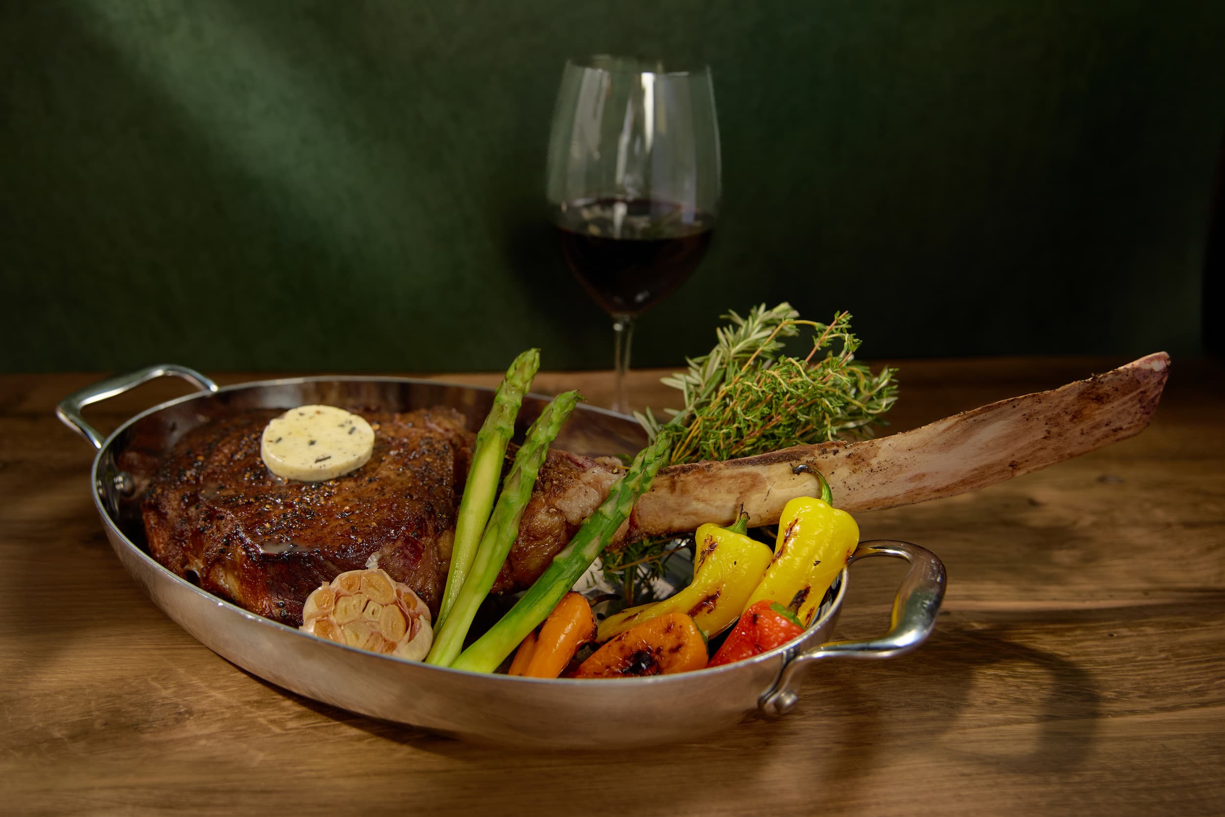 Tomahawk ribeye steak with asparagus and peppers at Carversteak NYC.