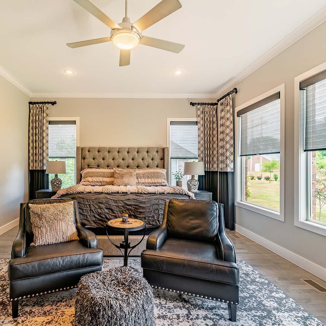 Protect your high-quality leather furniture from harmful UV rays with roller shades. Roller shades are incredibly versatile, blending perfectly into any home design. Here, these shades are combined with patterned drapery panels to match the earth tones in this stunning bedroom.