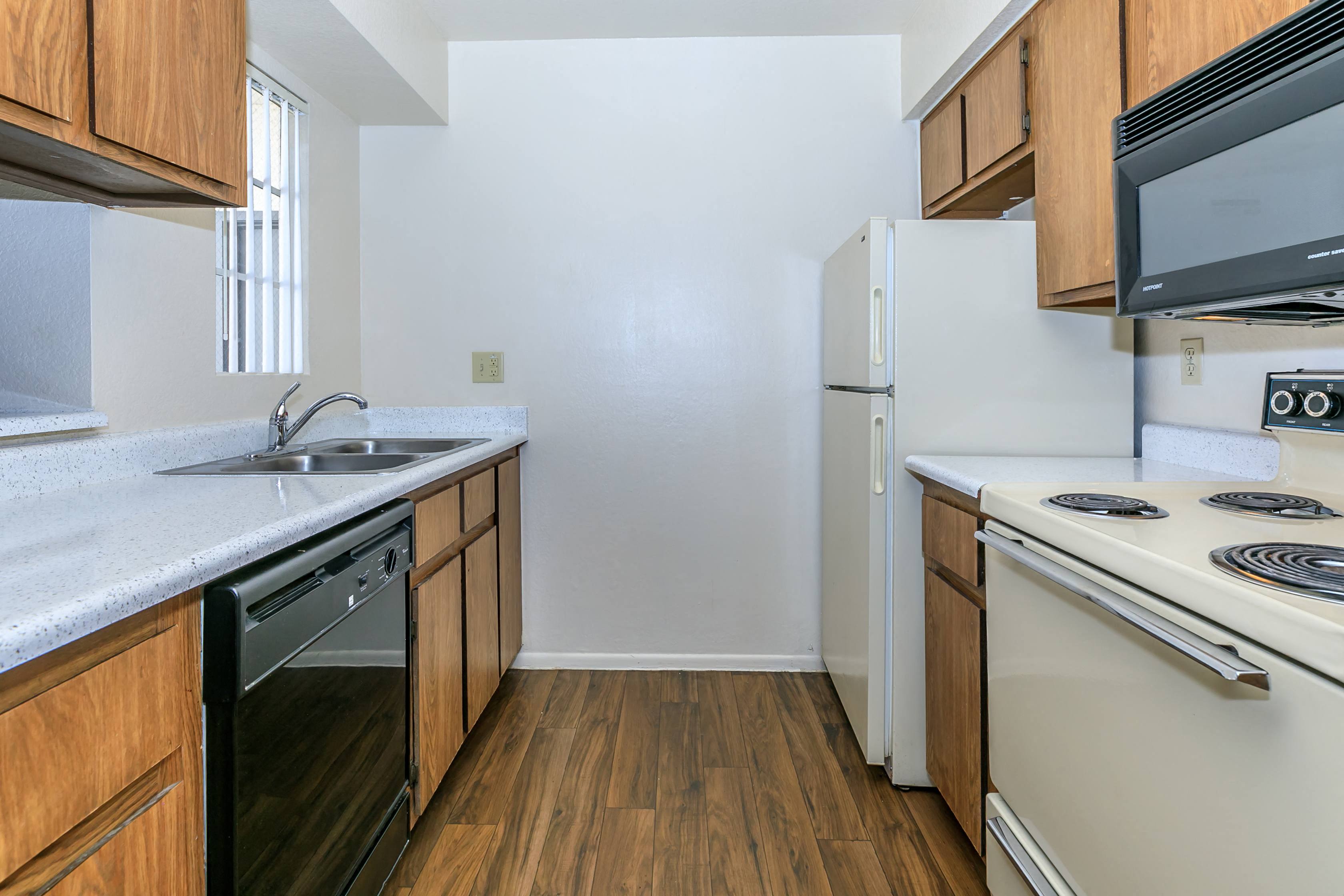 a kitchen with white appliances and wooden cabinets