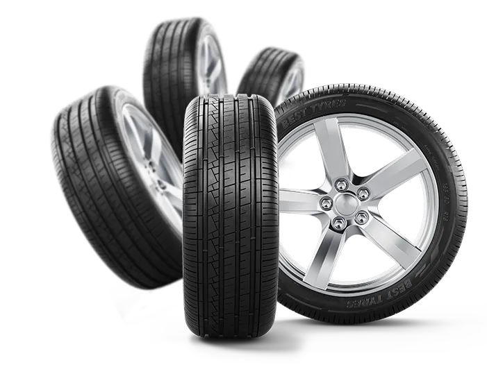A collection of four car tires and one alloy wheel, with the front tire prominently displayed. The tires have a clear tread pattern and some text on the sidewalls. The alloy wheel is silver with five spokes and has text on its rim. The arrangement suggests a product display or advertisement for tires.