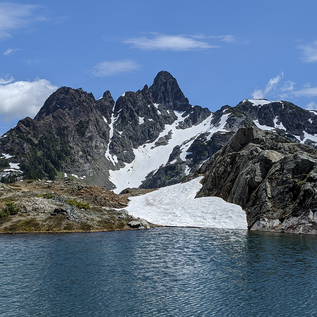 Calm alpine lake with a mountain in the background.