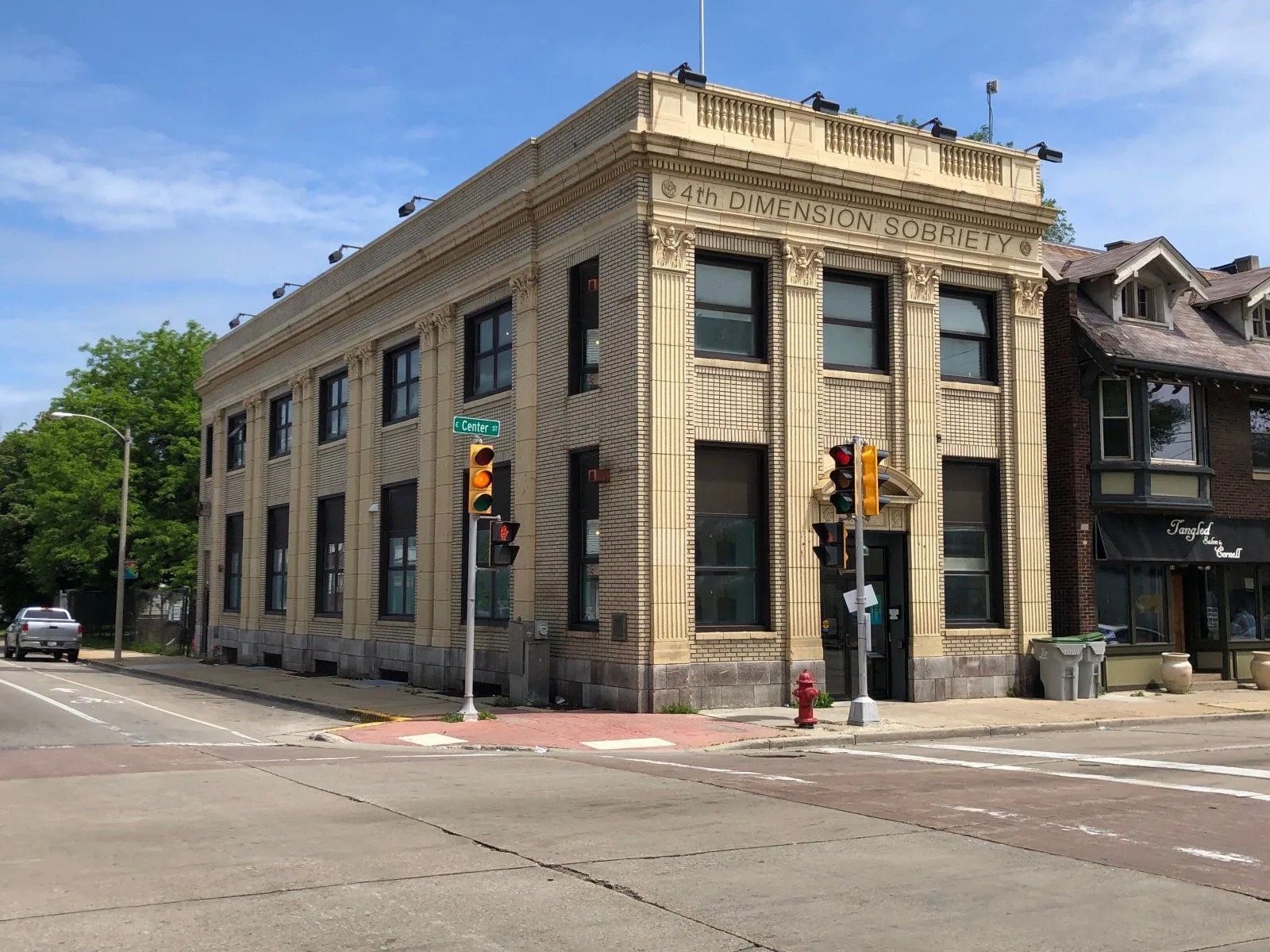 Historic 4th Dimension Sobriety building located on a city corner featuring classic architecture, large windows, decorative columns, and inviting entrance representing a trusted destination supporting recovery and sober community services.
