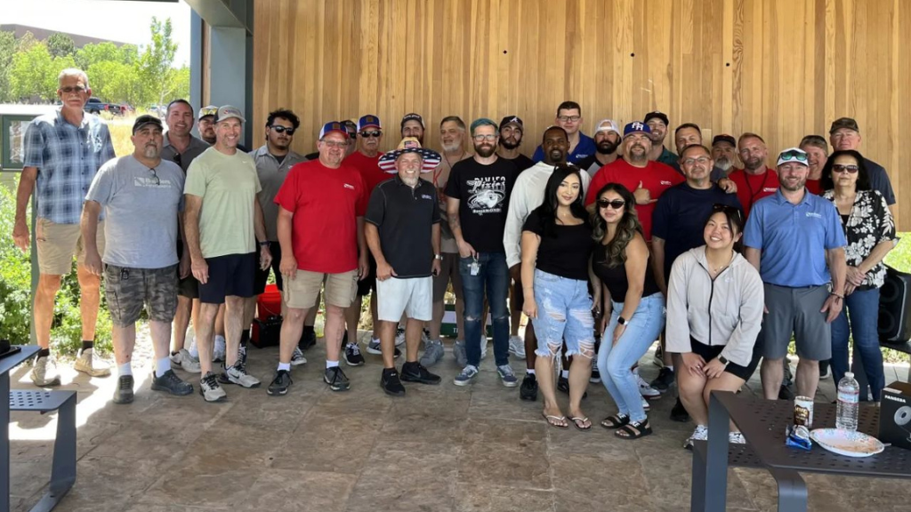 Builders FirstSource team members gathered outdoors during a company appreciation event, posing for a group photo at a branch location.