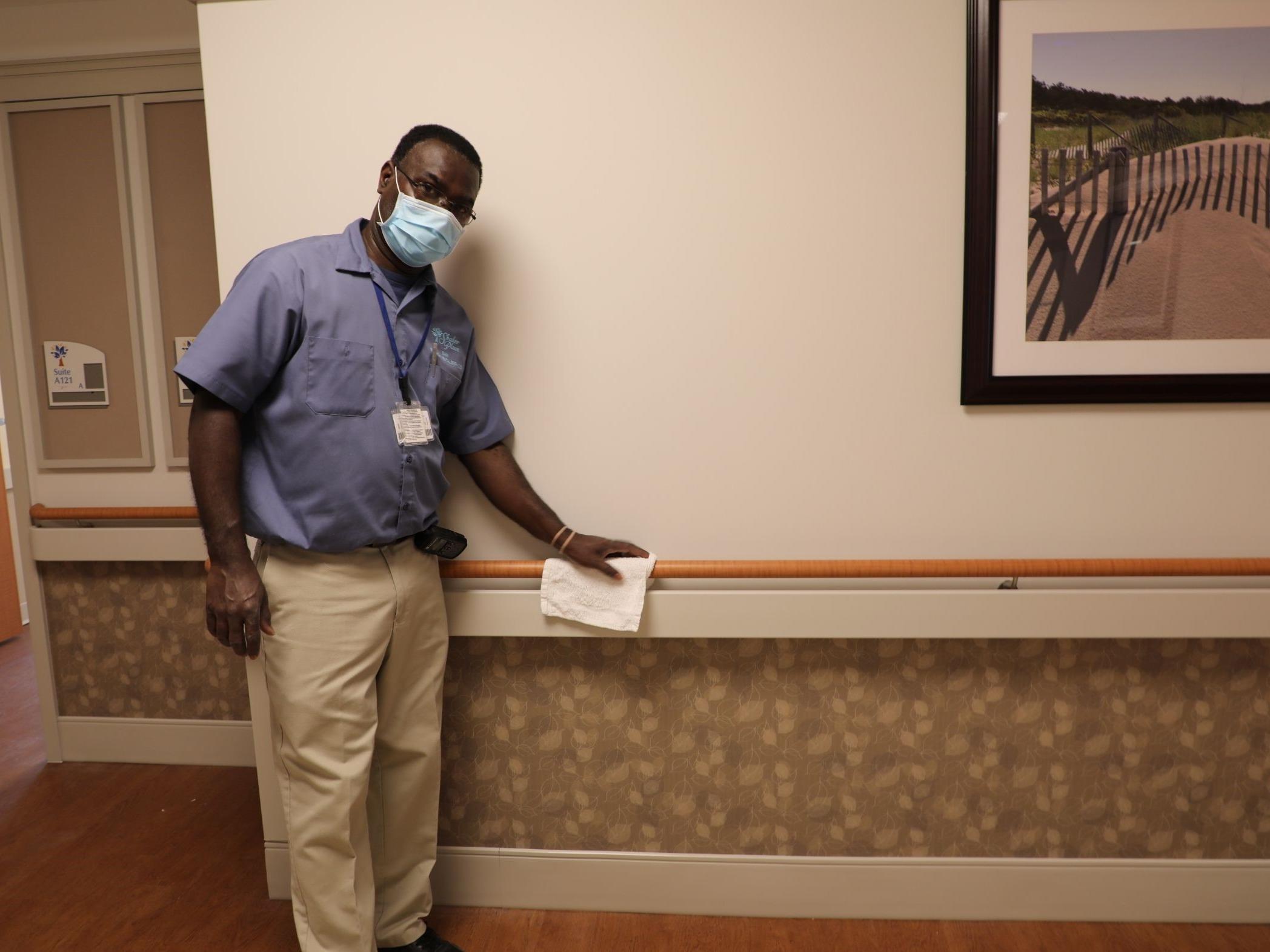 Shaker Place Rehabilitation and Nursing Center Employee cleaning hallway