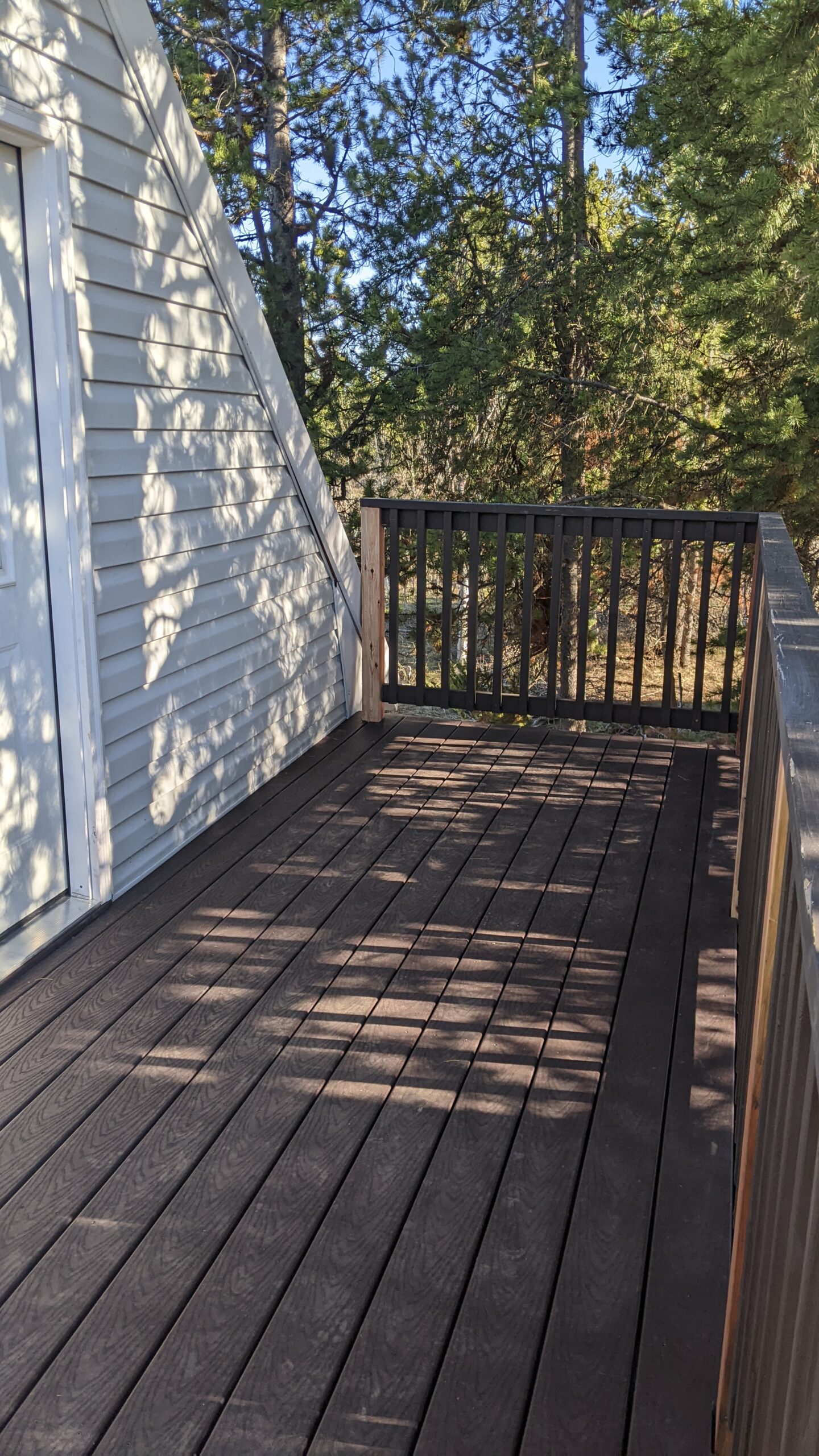 Extend your outdoor living possibilities with this custom deck by DeckPro LLC, which combines rustic elements with modern materials. We installed low-maintenance composite decking in a warm brown tone and paired it with a unique railing system that features natural wood posts and integrated wire mesh infill panels. For the ultimate in functional design, we included extensive built-in L-shaped bench seating, creating a cozy and inviting perimeter perfect for taking in scenic views.
