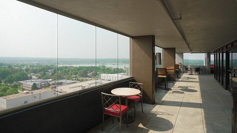 Enclosed exterior walkway with seating and Sloan's Lake in the distance