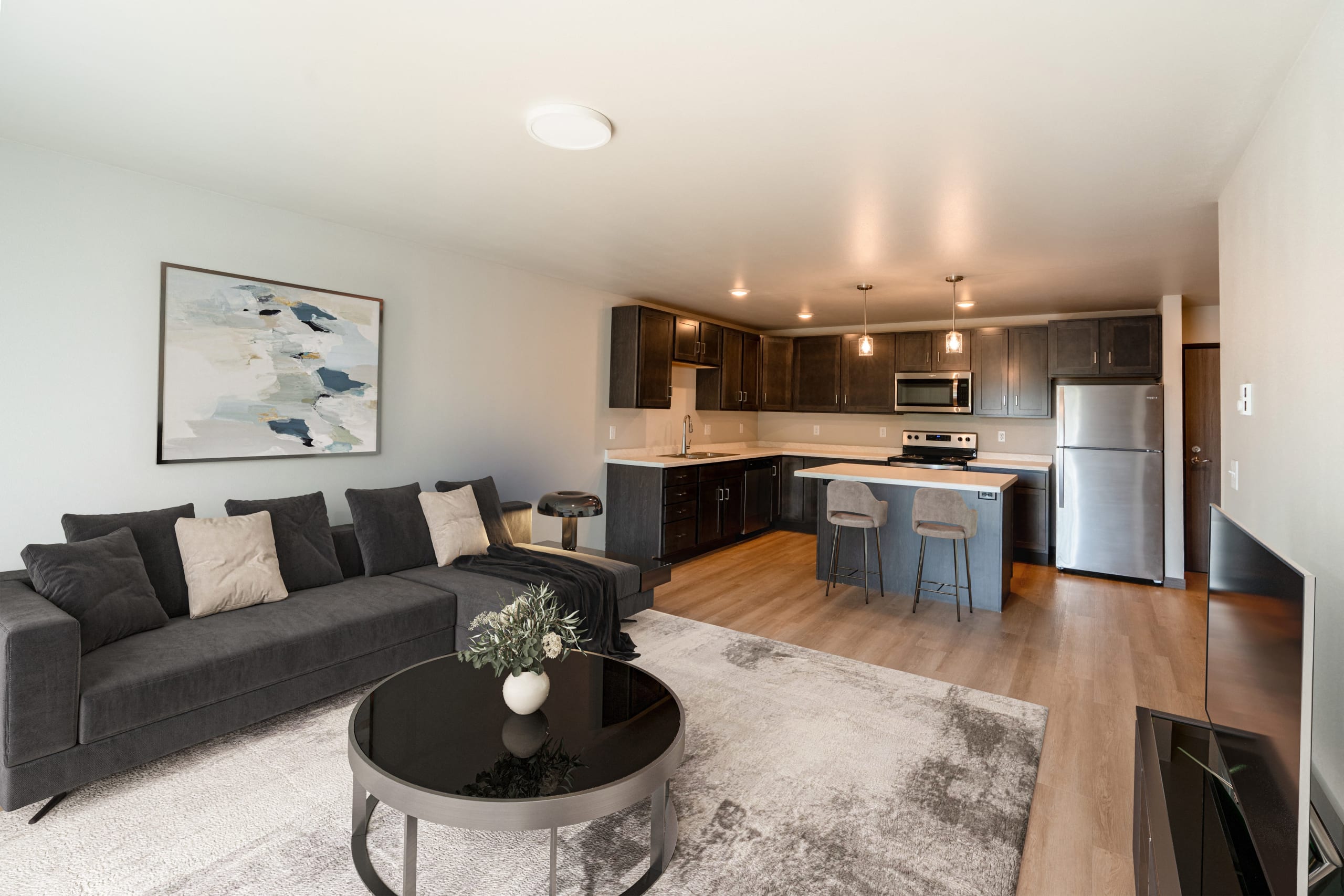 living room with a couch and a table in front of a kitchen