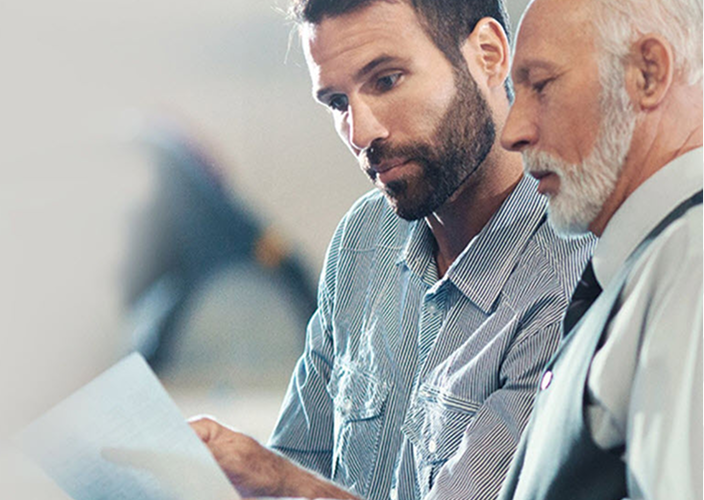 A son and father reviewing documents together.