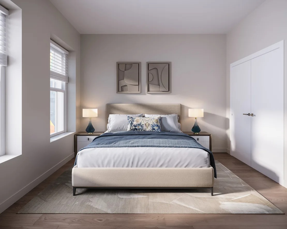 A bedroom with a bed, two lamps, and two framed pictures on the wall. 