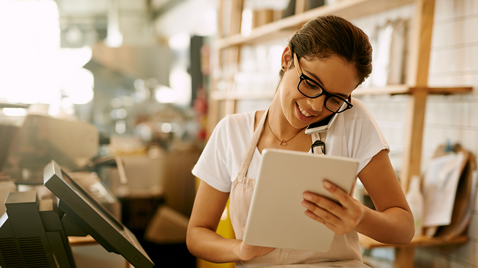 A woman on the phone looking at a tablet