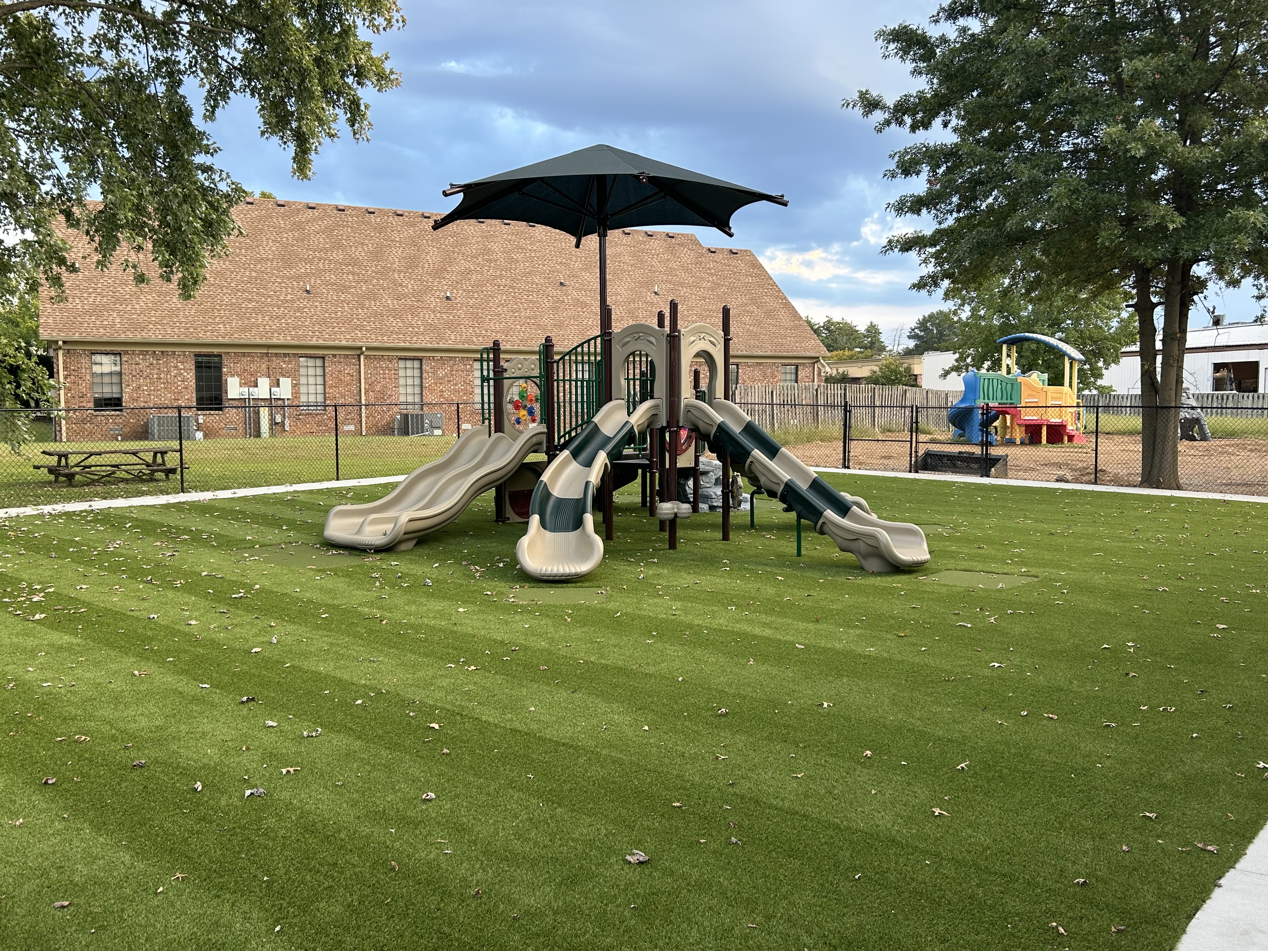 Large commercial metal playground with green and tan accents.