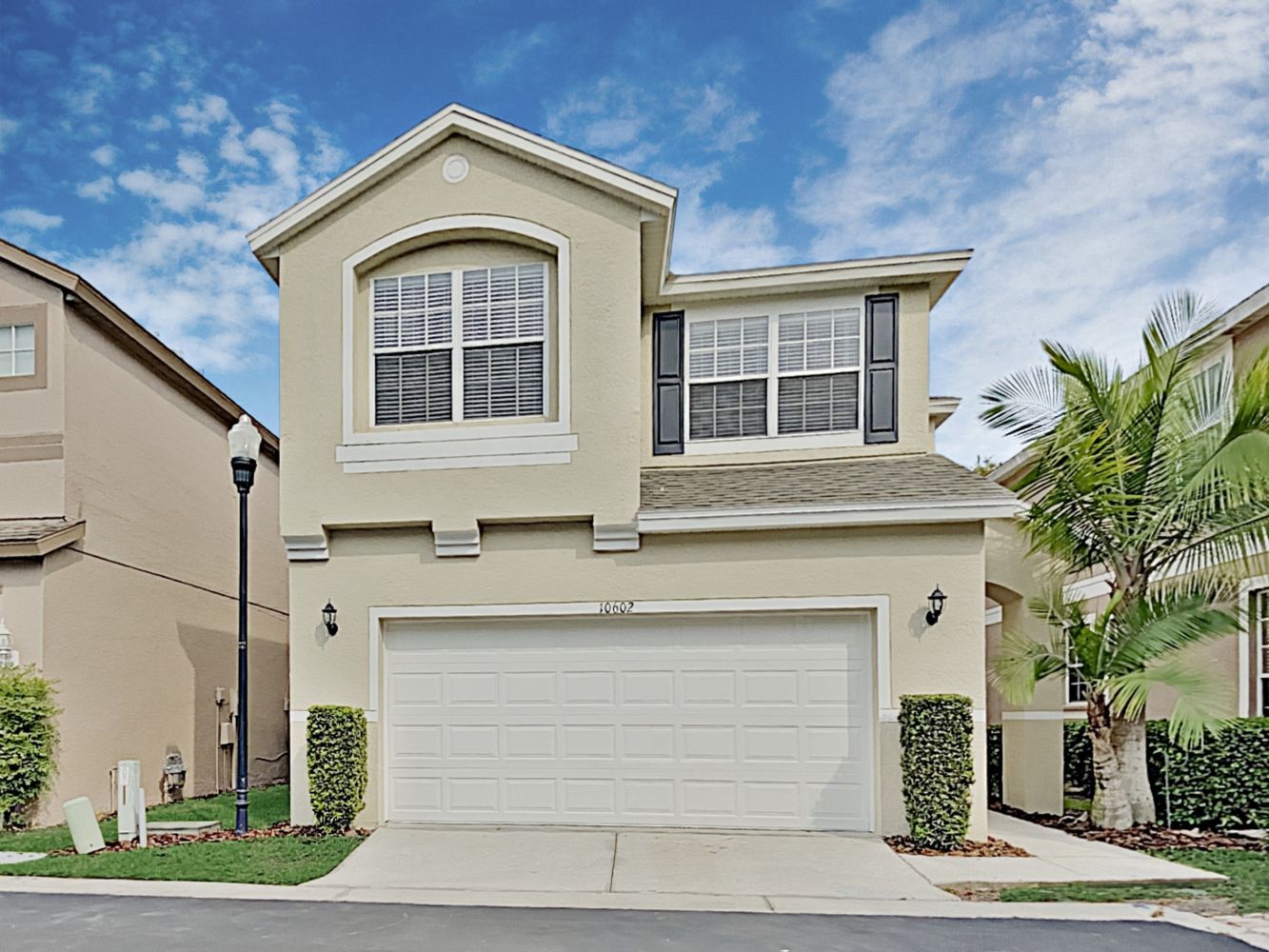 Front of home with driveway and two-care garage at Invitation Homes Tampa.