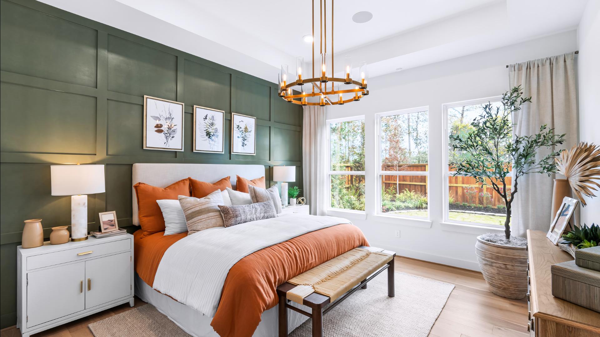 Spacious primary bedroom retreats with backyard views