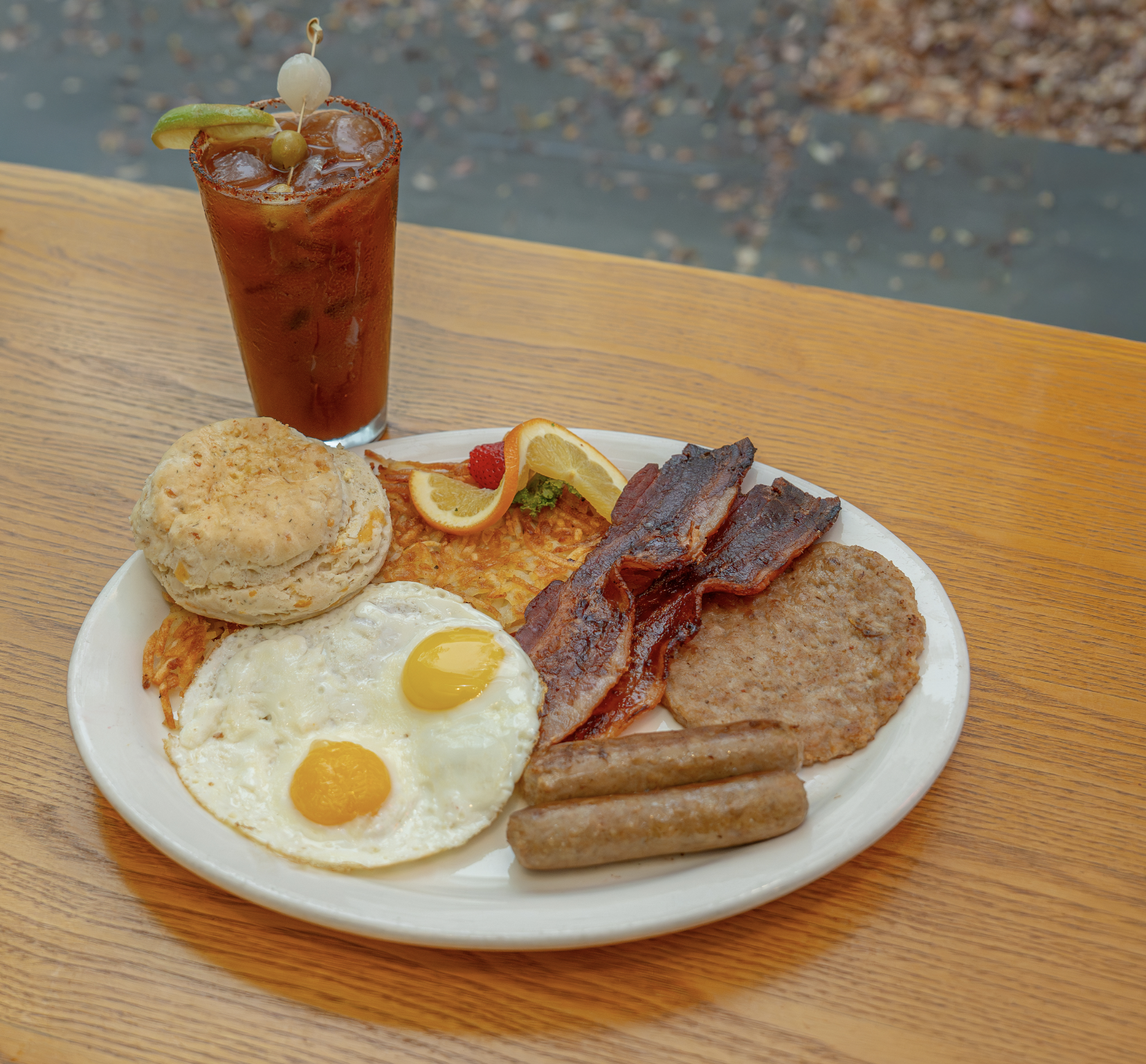 2 eggs with bacon strips or sausage, includes hashbrown or fresh fruit and choice of toast or homemade biscuit. Additional meat and a Bloody Mary are optional.