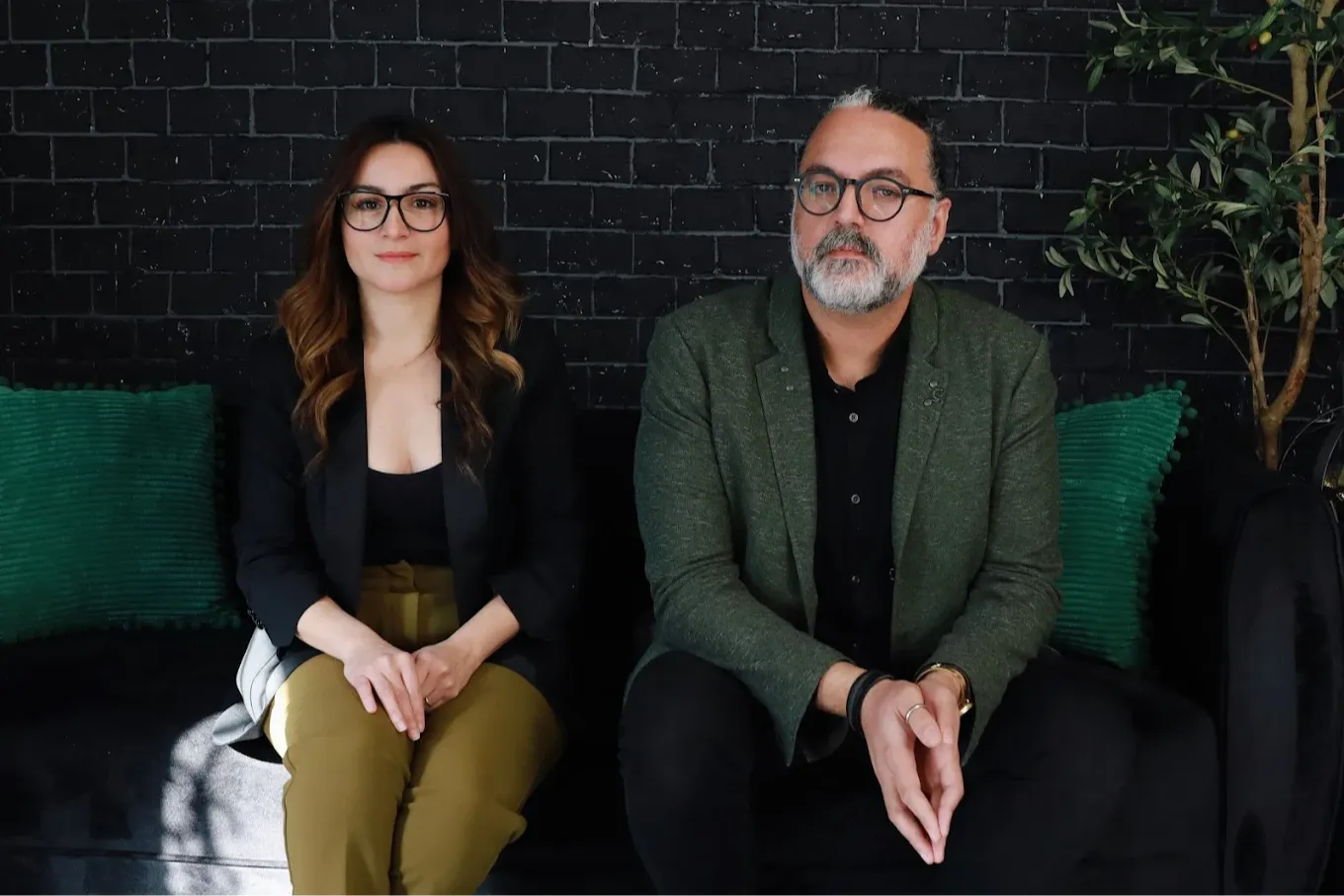 Maral Javanmard & Mo Kazemi the broker owners of XYZ Group Real Estate Las Vegas sitting on a couch in the XYZ headquarters