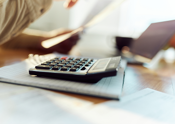 A calculator laying on top of a notepad.