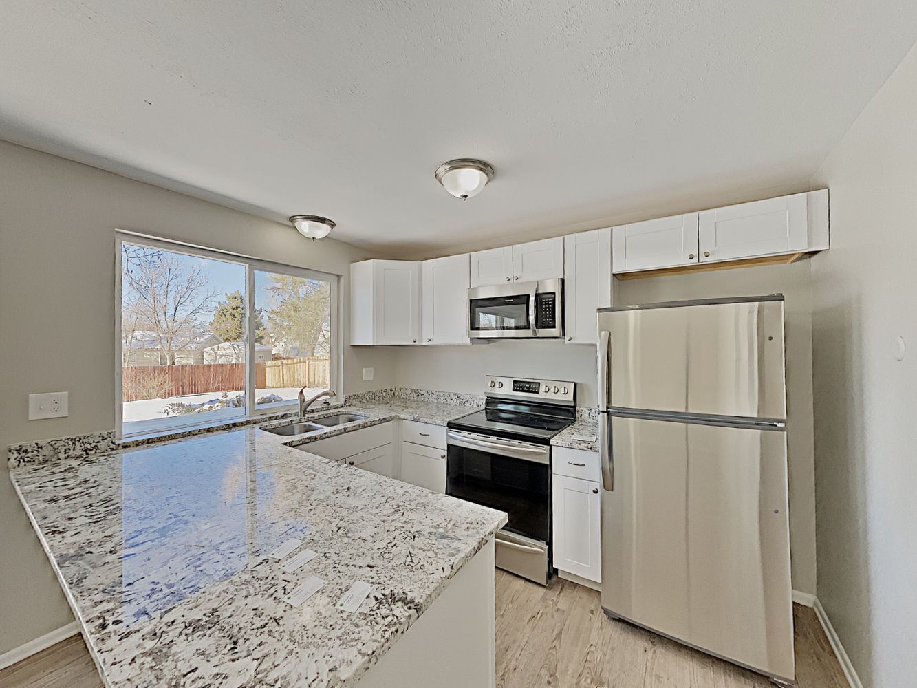 Kitchen with granite countertops and stainless-steel appliances at Invitation Homes Denver.