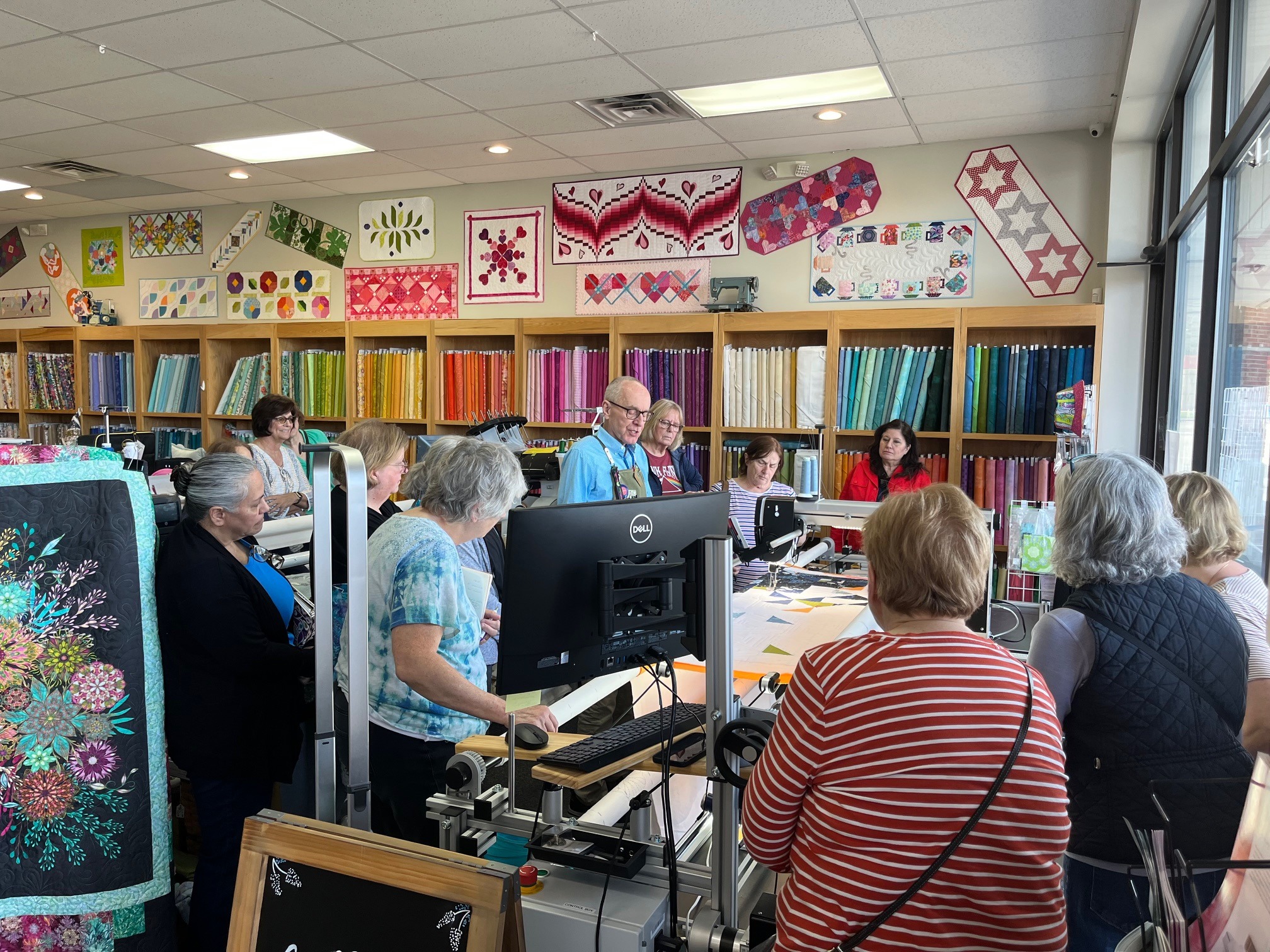 Quilters gather for a Decorative Stitch demonstration, learning new quilting techniques through a live longarm and machine quilting presentation. A hands-on workshop focused on creativity, skill building, and inspiration.