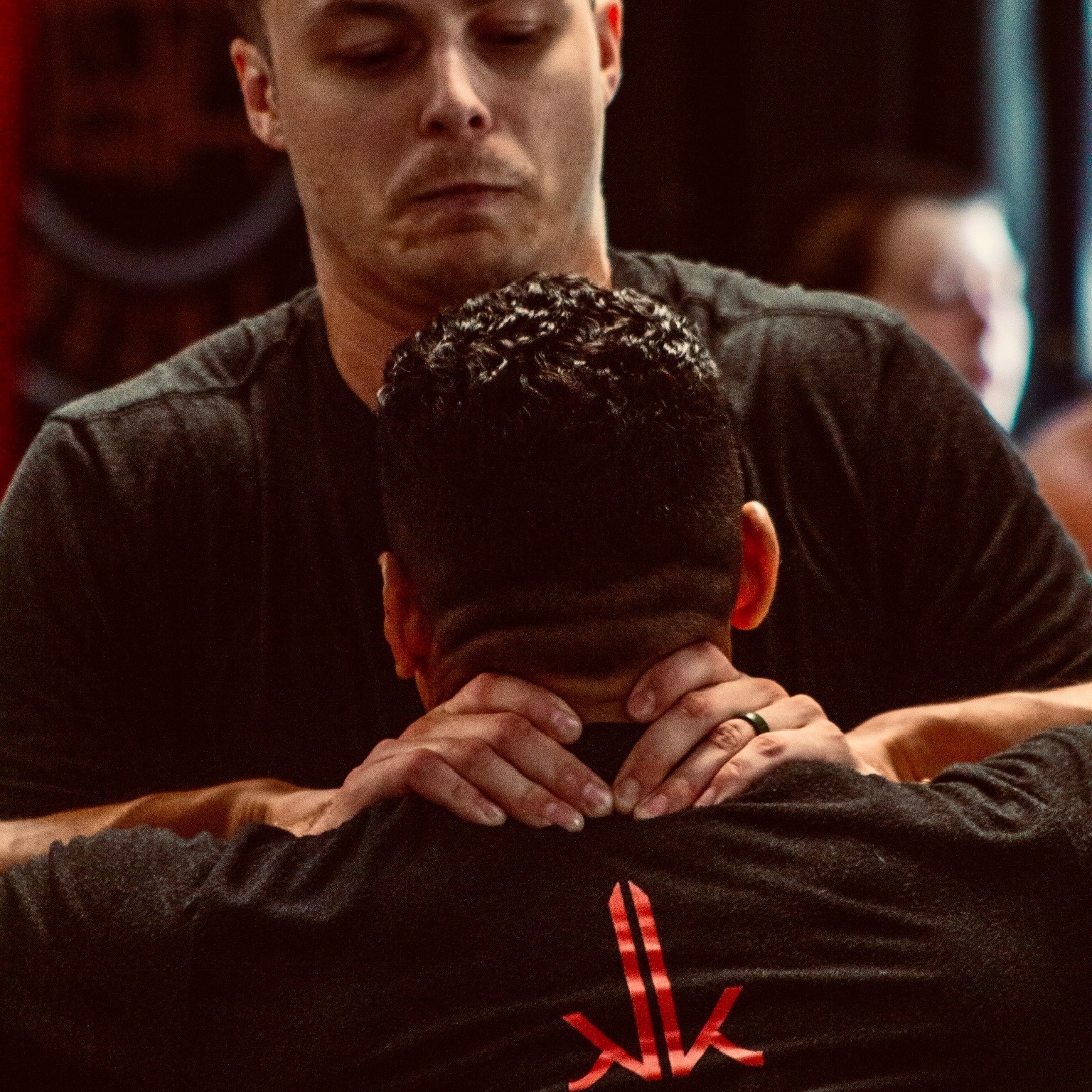 An student training a neck control on another student during an evening class.