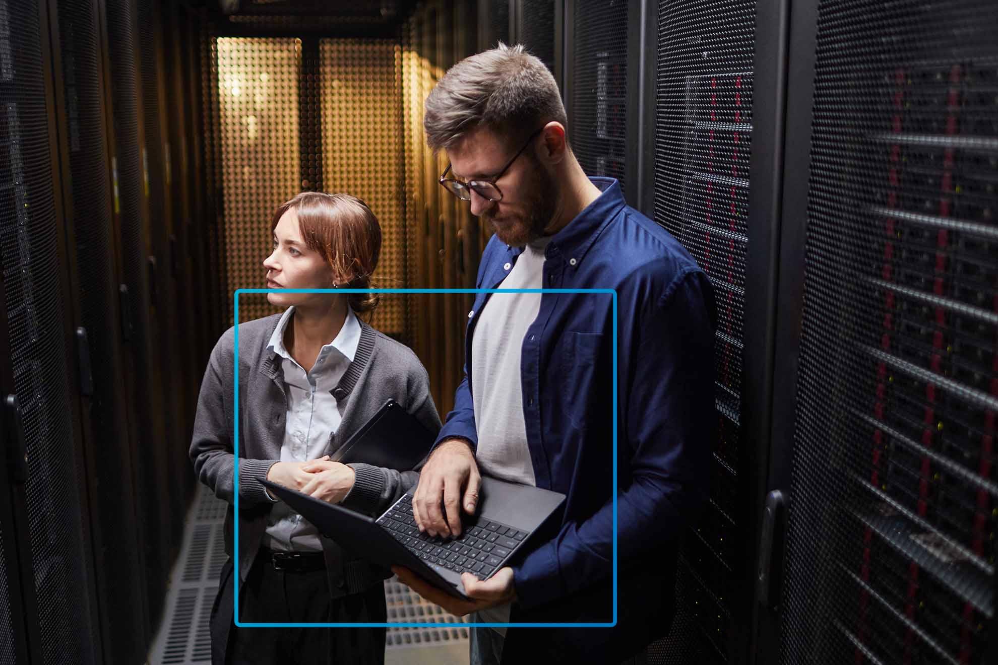 An employee is looking at his laptop while another one is looking somewhere