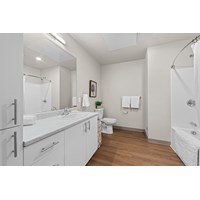 A white bathroom with a wooden floor and white fixtures.at Terracina Vista, Oregon