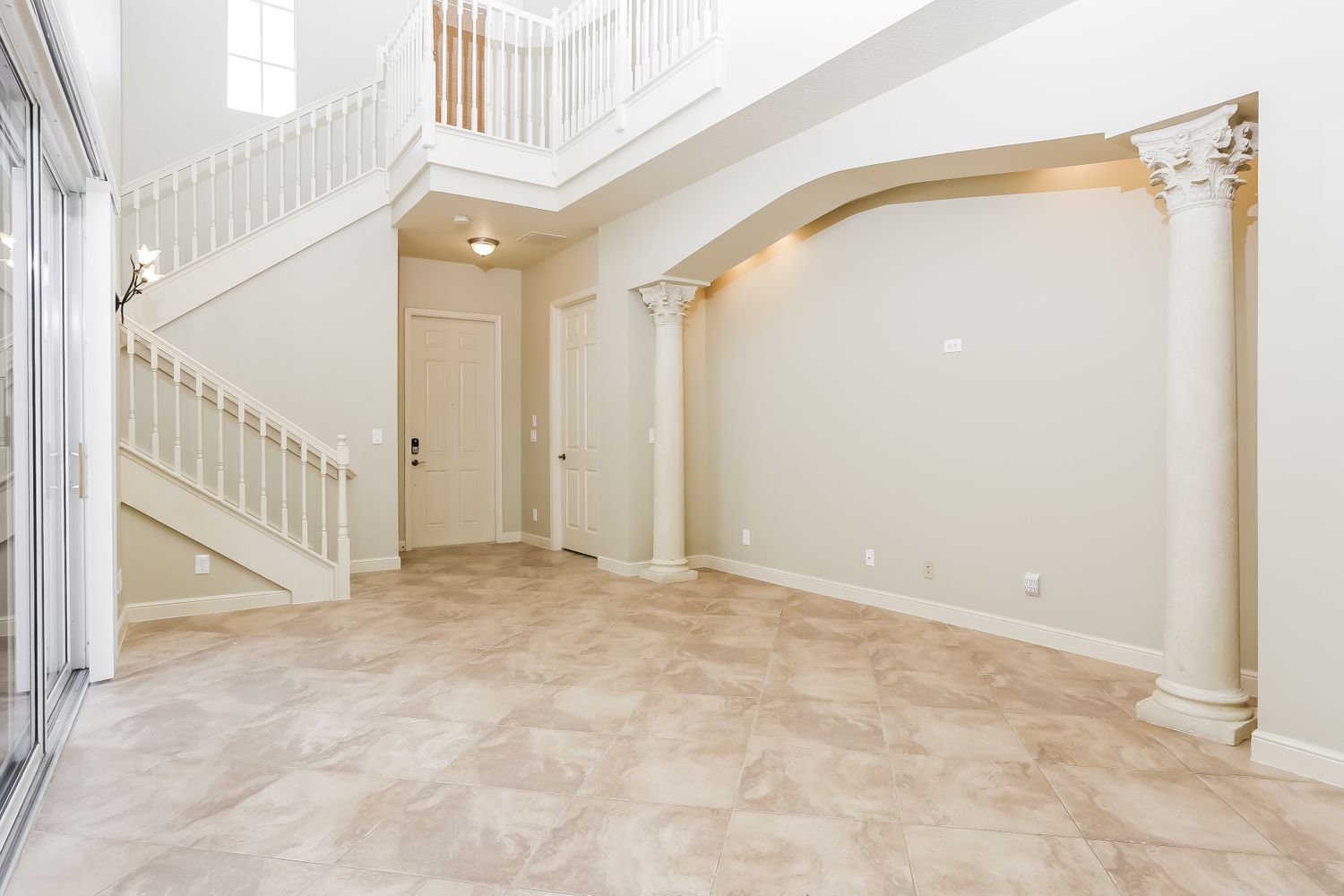 Living space with tile flooring and access to the backyard at Invitation Homes South Florida.